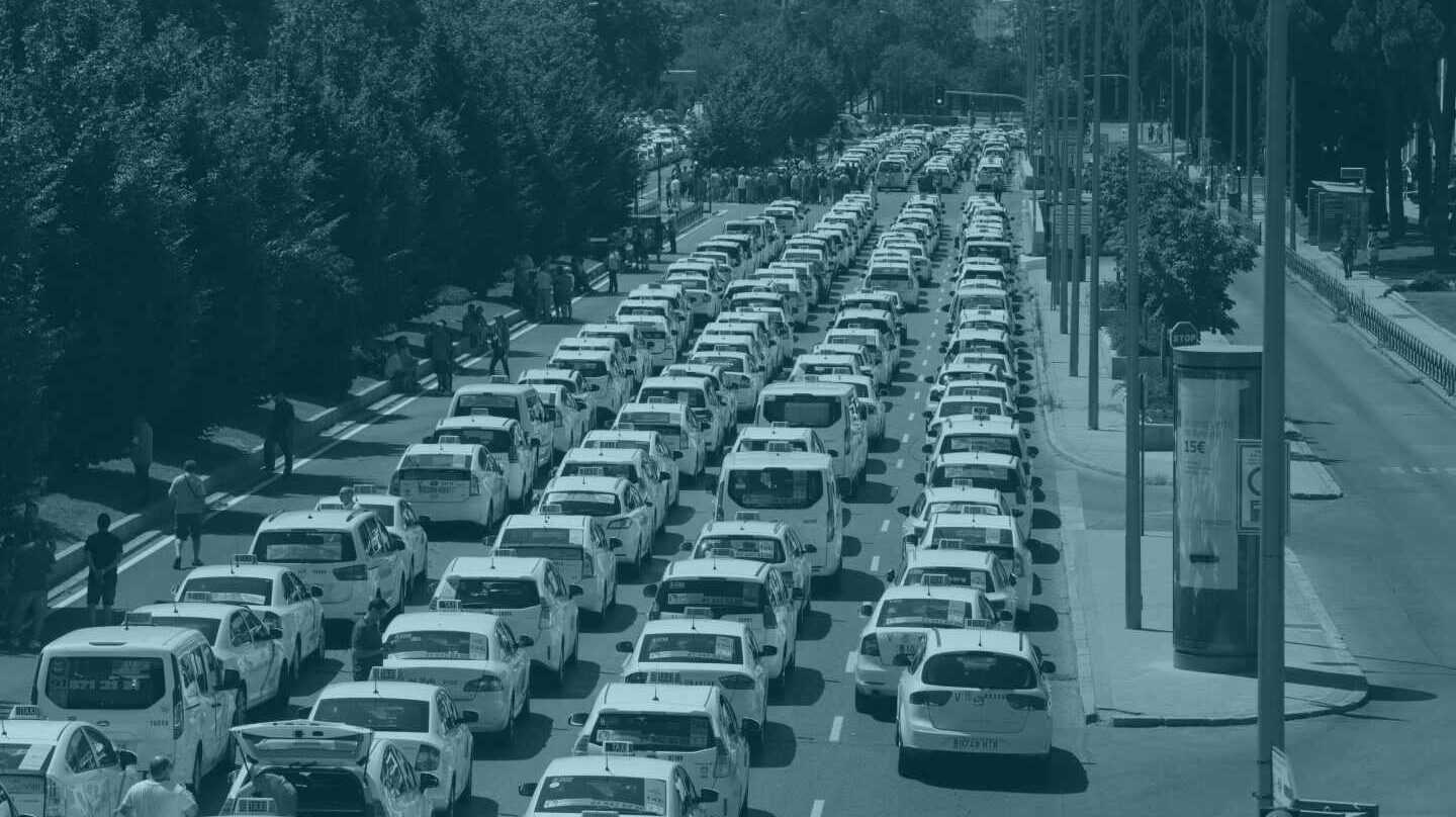 Un grupo de taxis permanecen concentrados a su paso por el ministerio de Fomento, en Madrid.