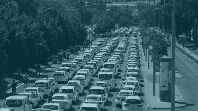 Un grupo de taxis permanecen concentrados a su paso por el ministerio de Fomento, en Madrid.