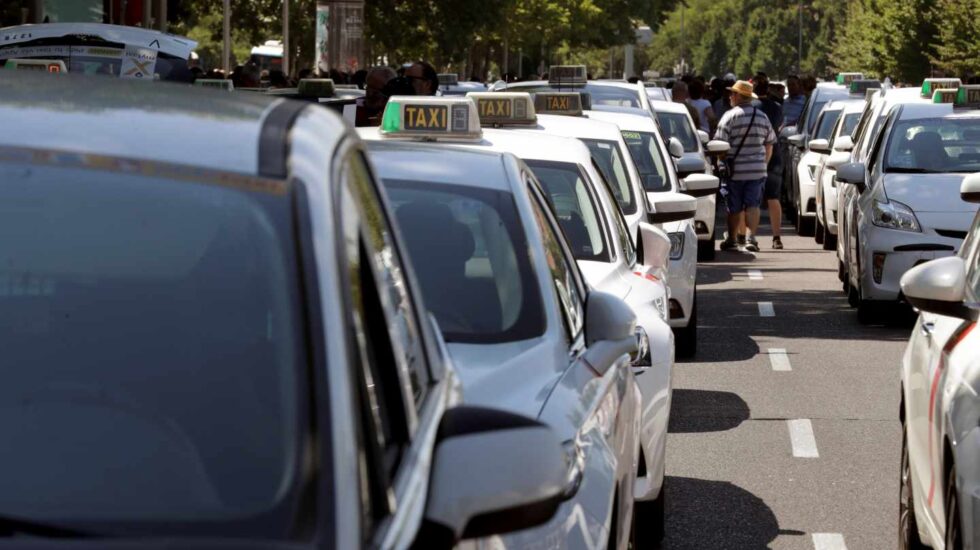Un grupo de taxis permanecen concentrados a su paso por el ministerio de Fomento, en Madrid.