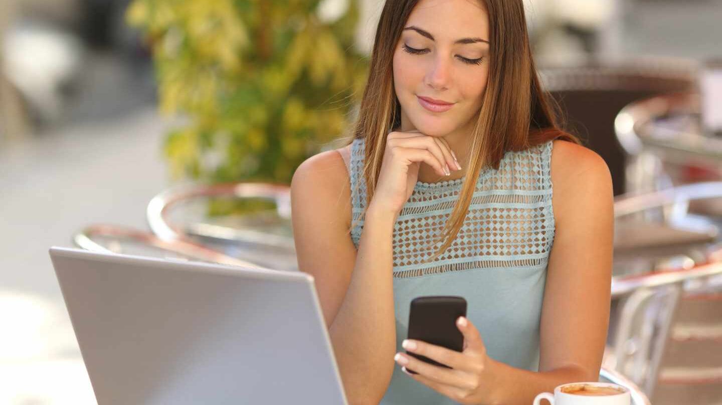 Una chica mirando su teléfono móvil.