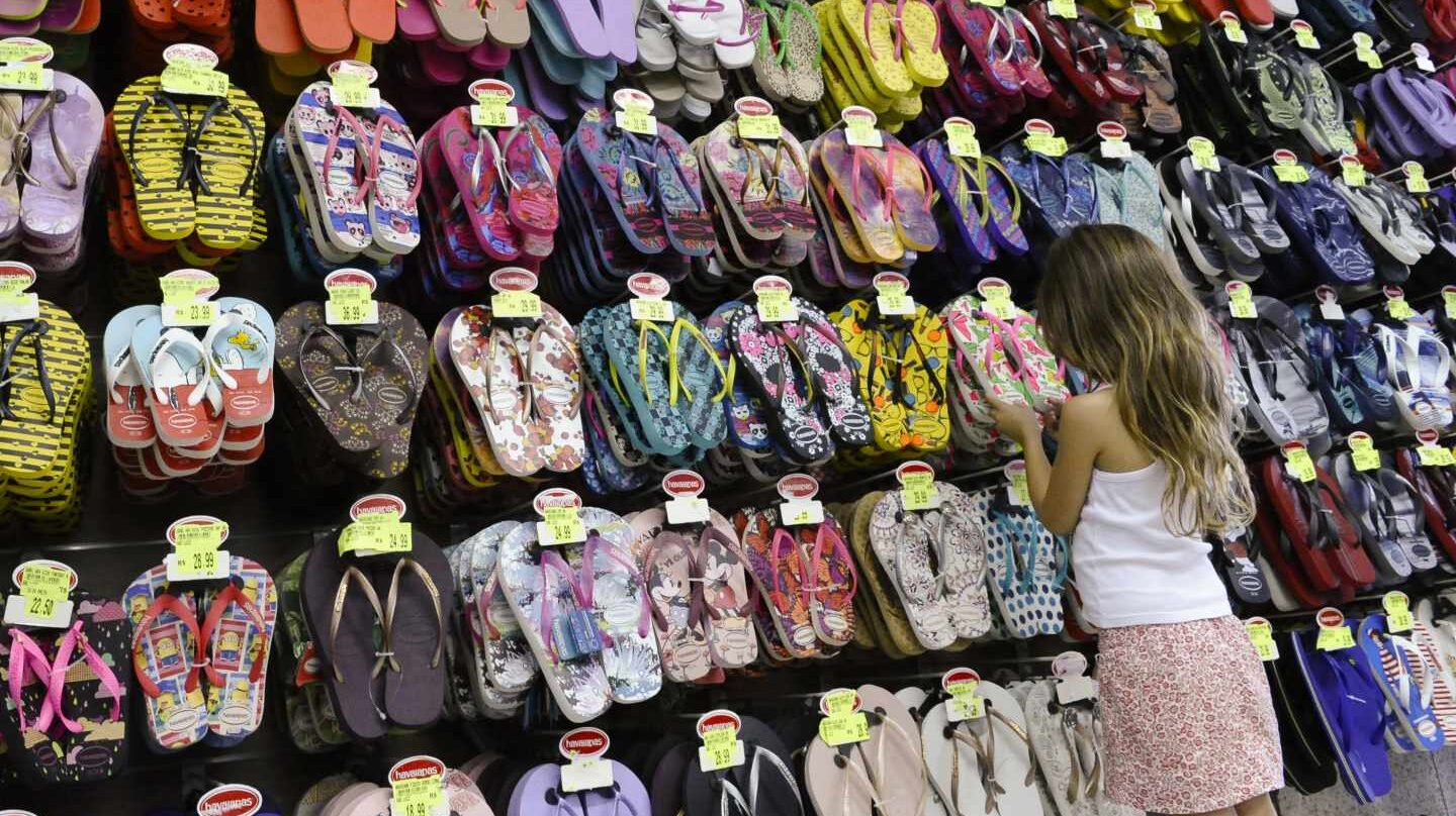 Una niña mirando sandalias en una tienda