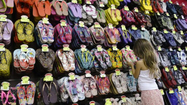 Una niña mirando sandalias en una tienda