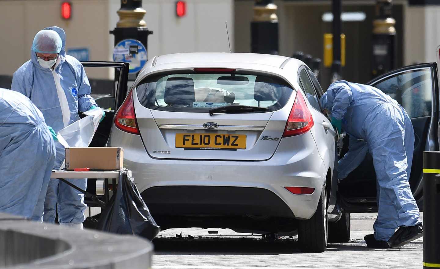 Oficiales forenses examinan el coche que chocó contra las barreras del Parlamento.