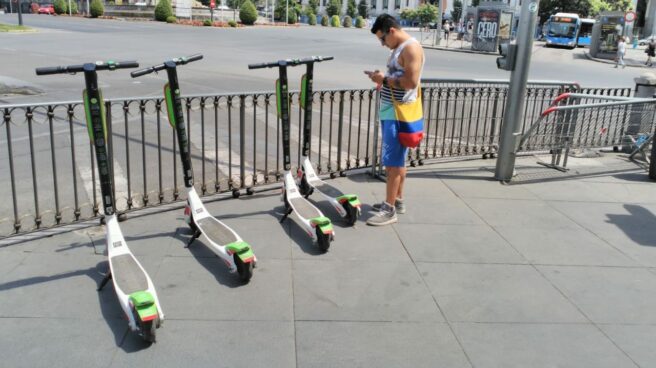 Un usuario desbloquea uno de los patinetes de Uber en el centro de Madrid. Un usuario desbloquea uno de los patinetes de Uber en el centro de Madrid.