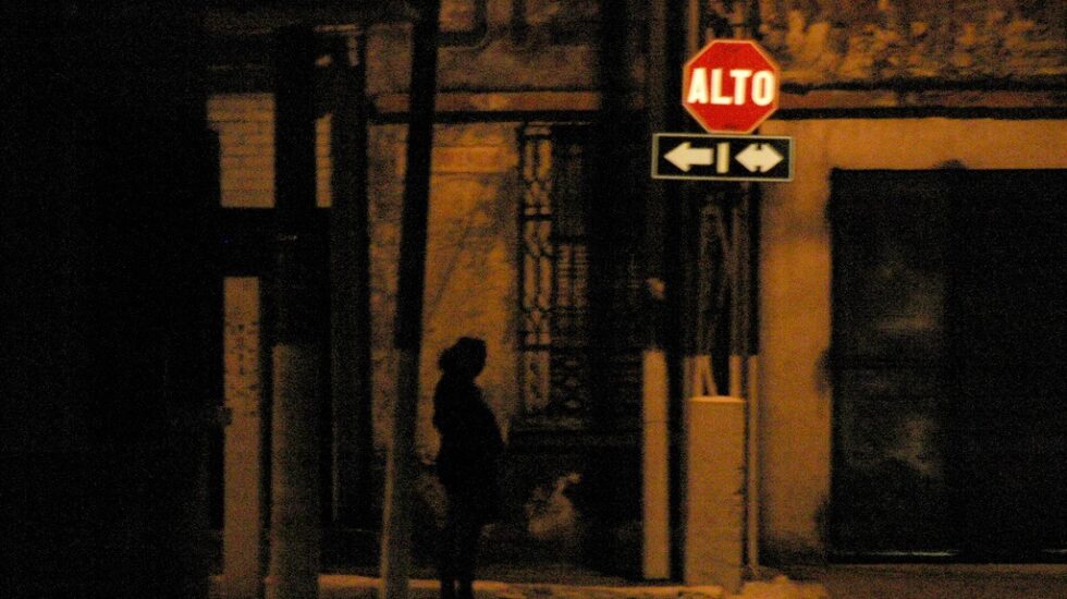 Prostituta de noche en una esquina.