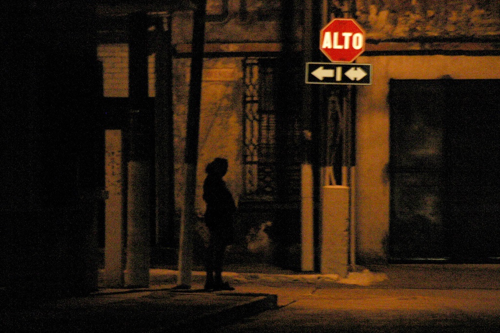 Prostituta de noche en una esquina.