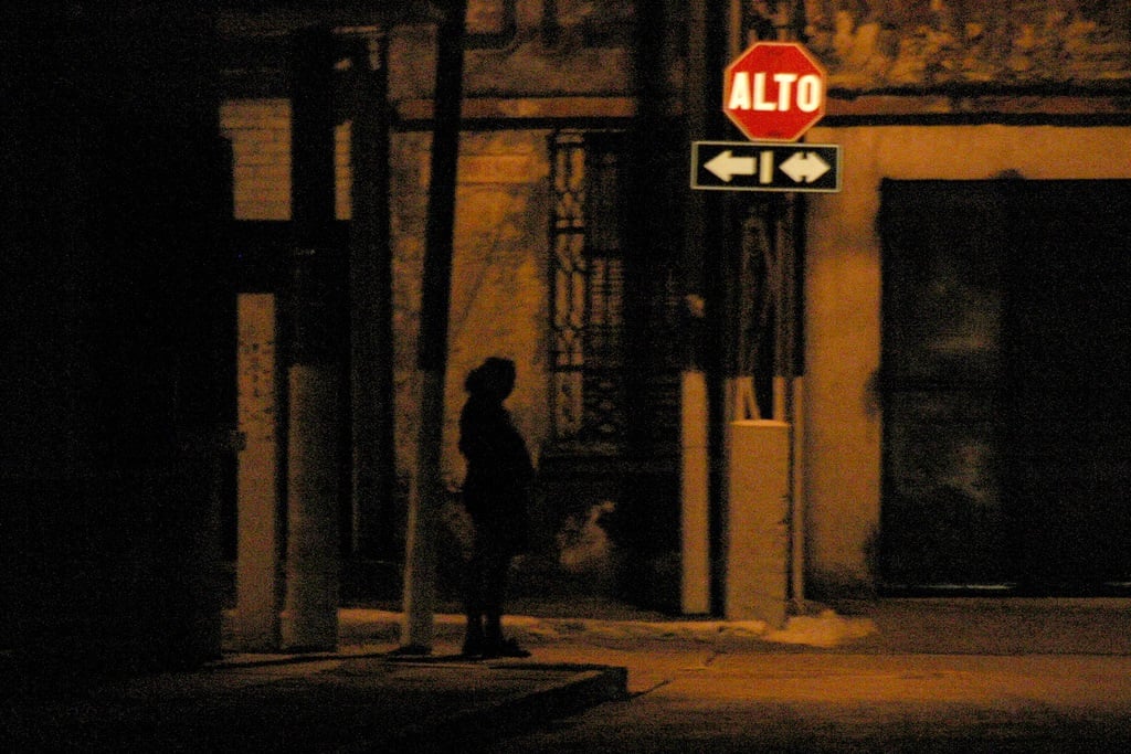 Prostituta de noche en una esquina.