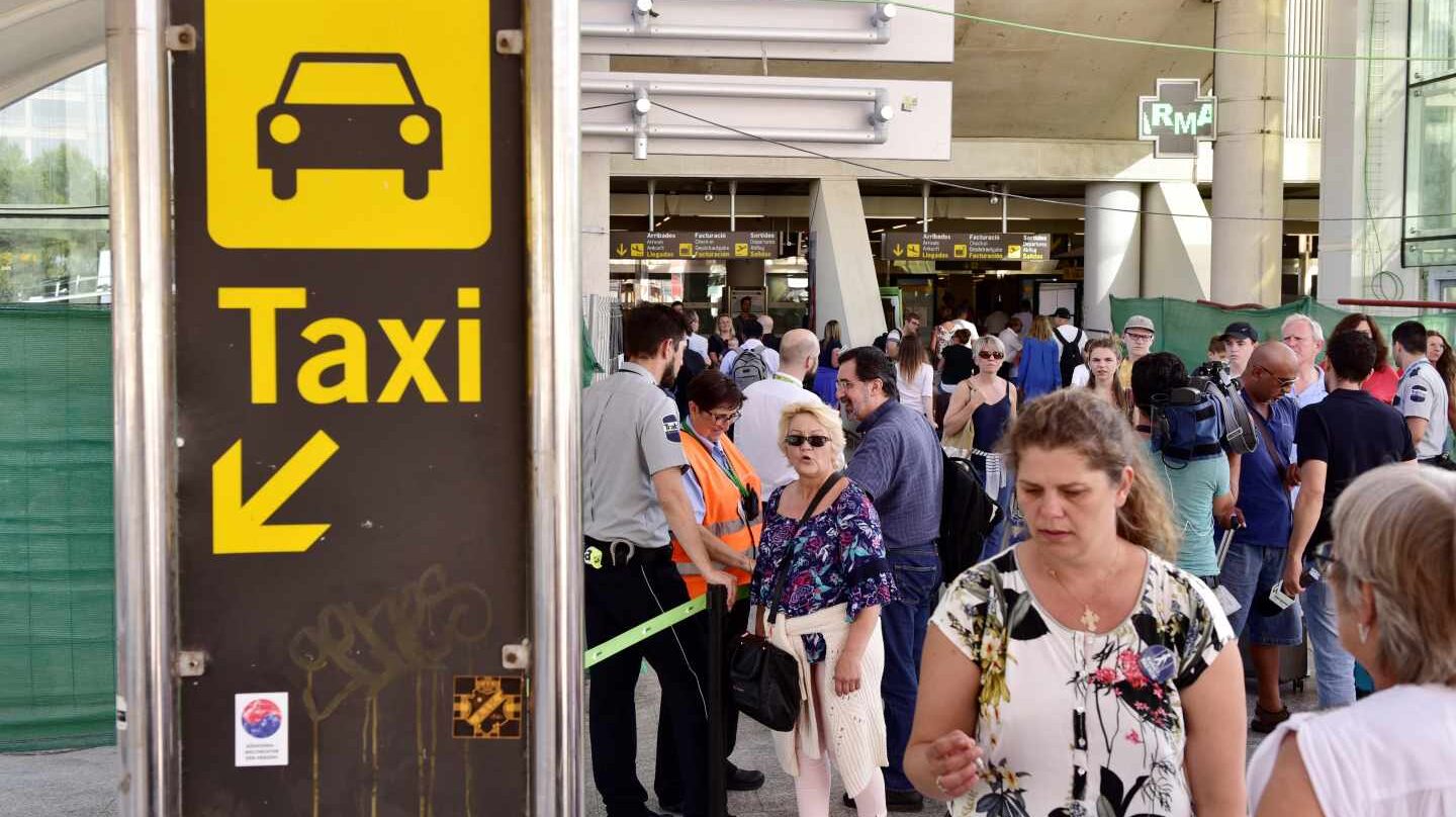 Varios turistas esperan en la cola del Aeropuerto de Palma para coger un taxi.