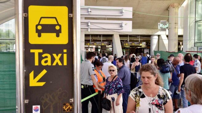 Varios turistas esperan en la cola del Aeropuerto de Palma para coger un taxi.