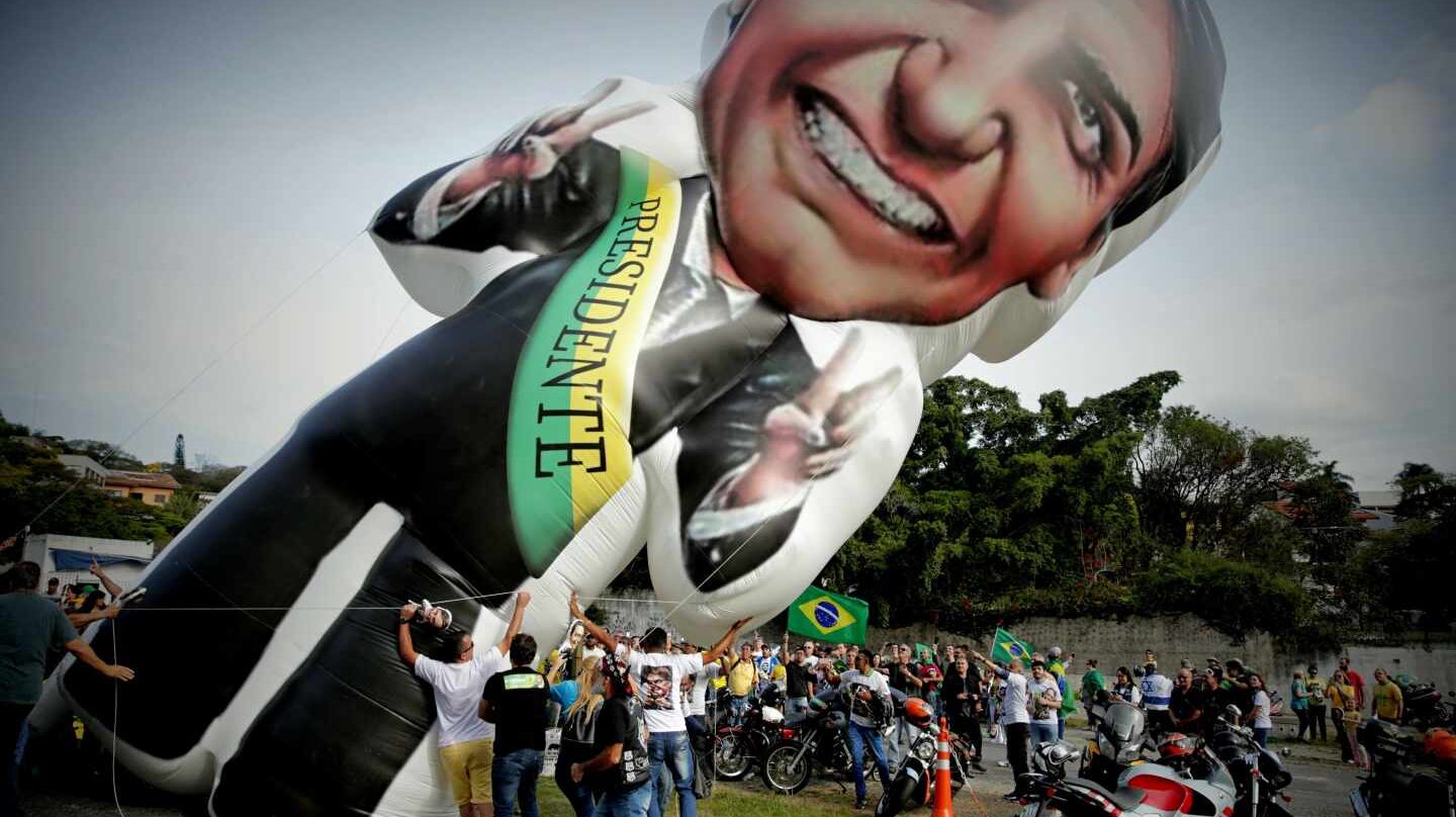 Seguidores del candidato ultraderechista brasileño Jair Bolsonaro elevan un globo con su imagen.