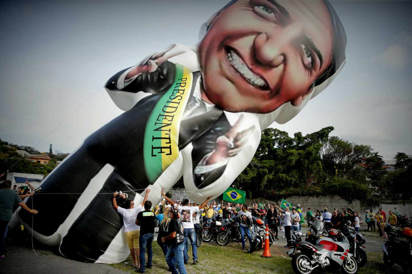 Seguidores del candidato ultraderechista brasileño Jair Bolsonaro elevan un globo con su imagen.