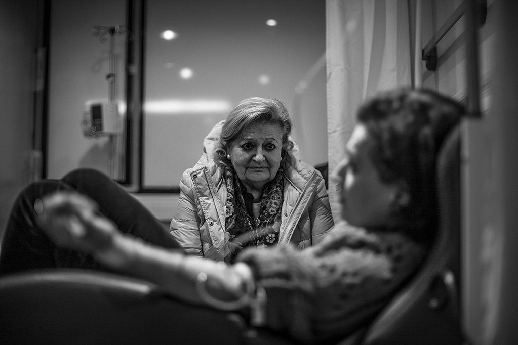 La madre de Piedad, vigila a su hija dormida mientras recibe quimioterapia en el Hospital Universitario Reina Sofia, Murcia, España, Diciembre 2017.