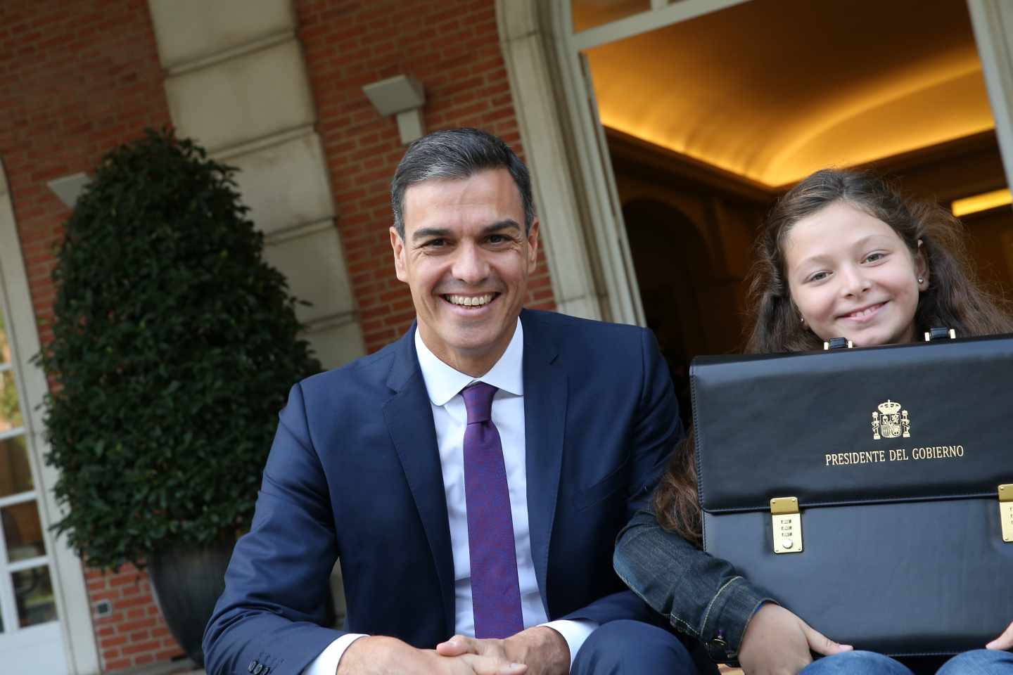 Pedro Sánchez e Irene, con la cartera de presidente, a las puertas de La Moncloa.