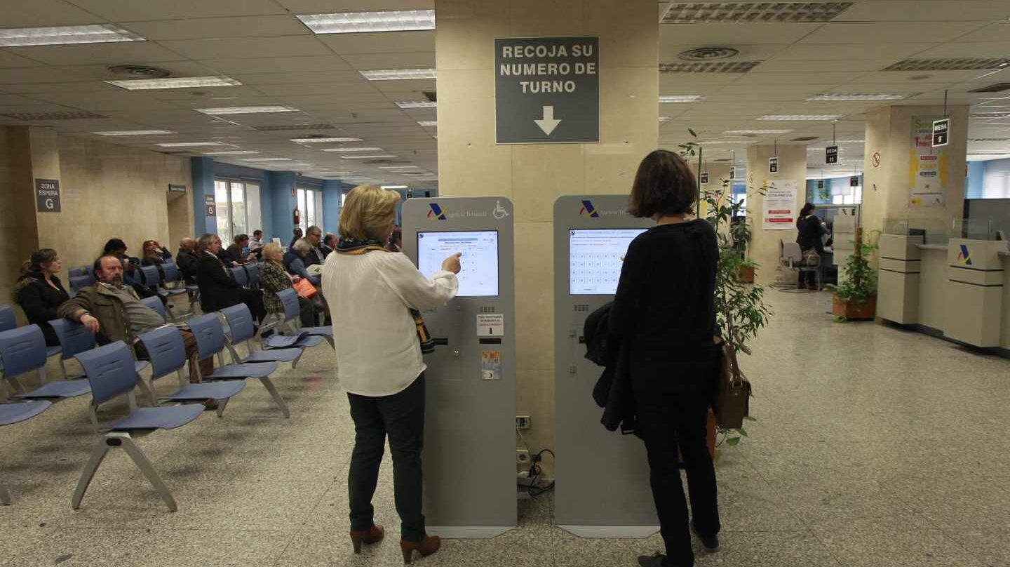 Dos mujeres piden turno en una oficina de la Agencia Tributaria.