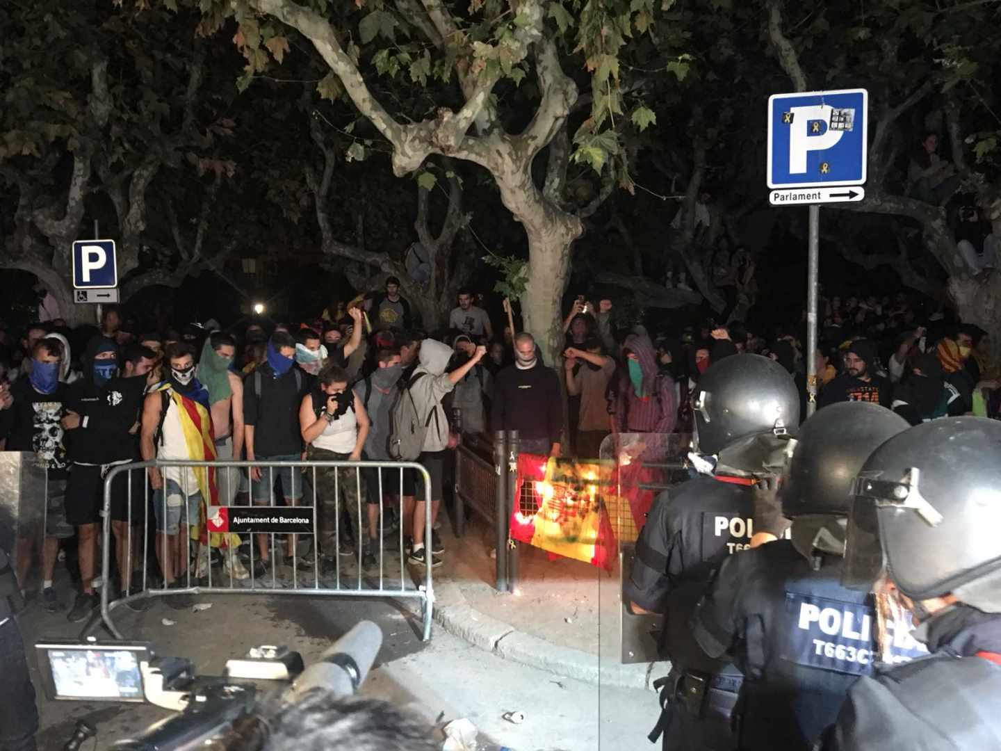 Los radicales de los CDR queman banderas de España mientras los Mossos se preparan para cargar frente al Parlament.