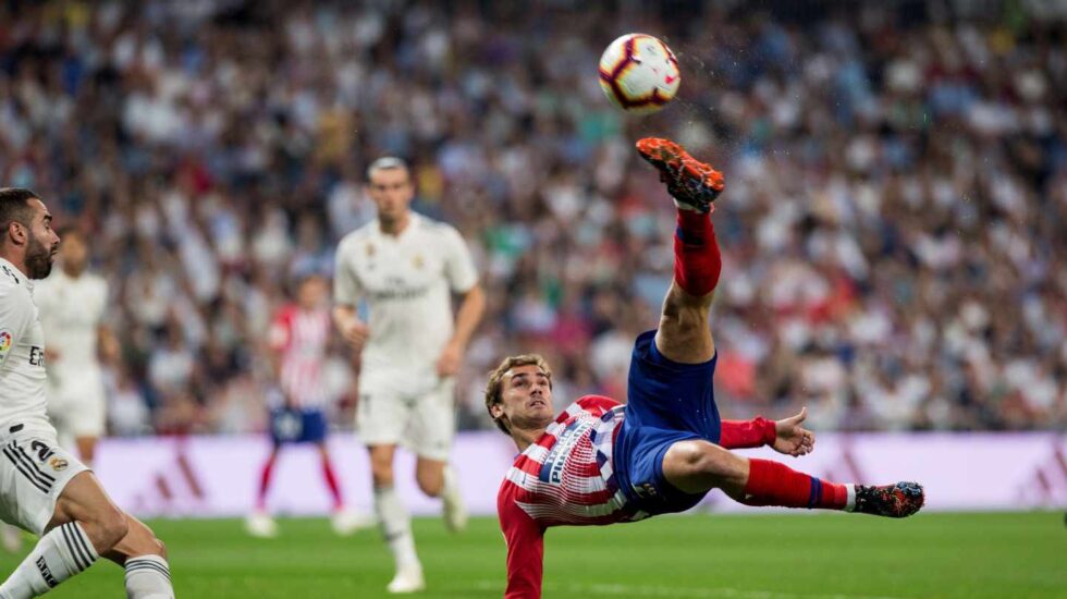 El jugador del Atlético de Madrid Antoine Griezmann remata un balón en el partido frente al Real Madrid.