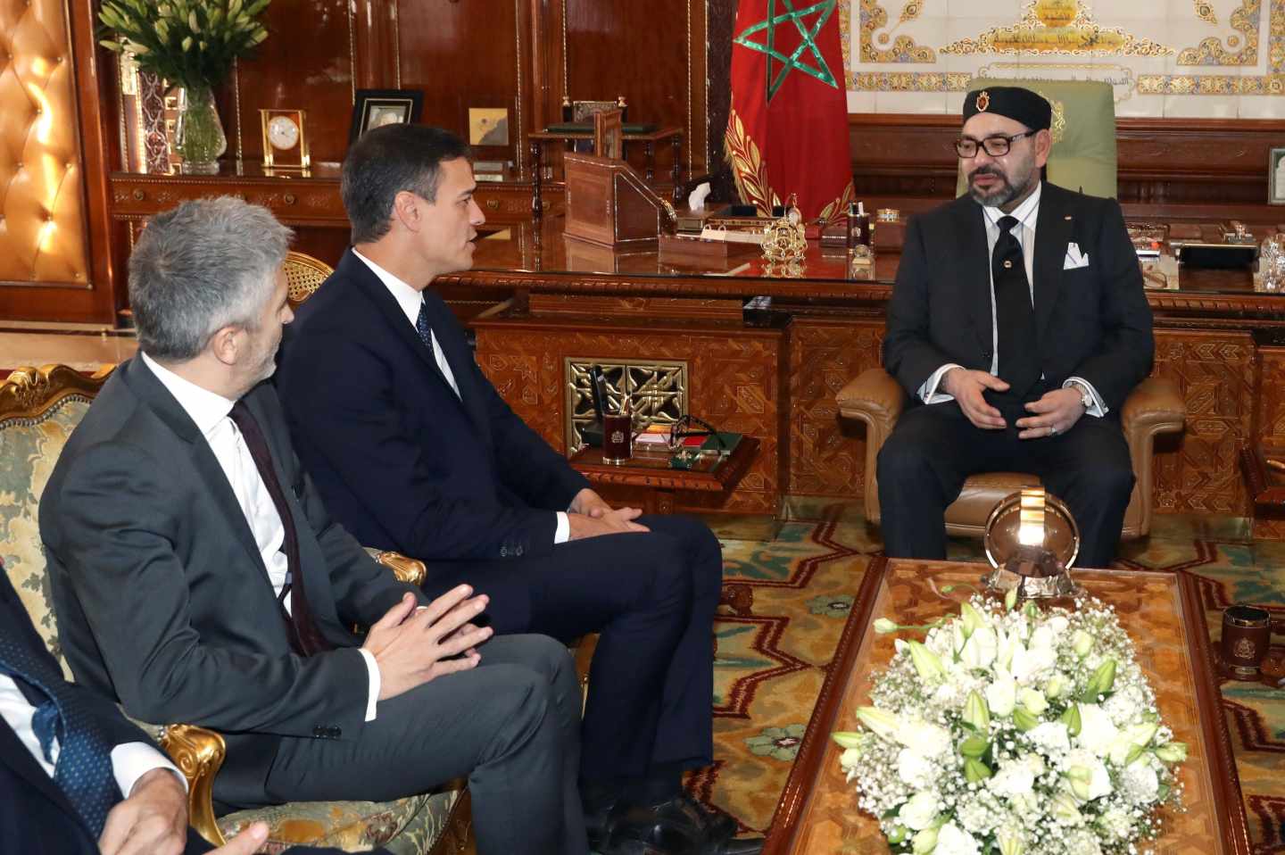 El presidente del Gobierno español, Pedro Sánchez (2i), junto al ministro del Interior, Fernando Grande-Marlaska (i), durante la reunión que ha mantenido hoy con el rey Mohamed VI (c) de Marruecos.