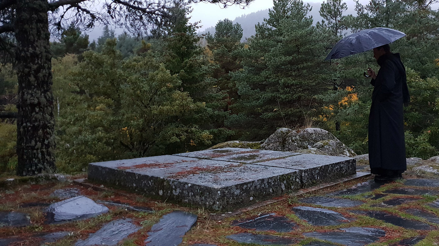 Un monje observa una de las tumbas en el cementerio del Valle de los Caídos.