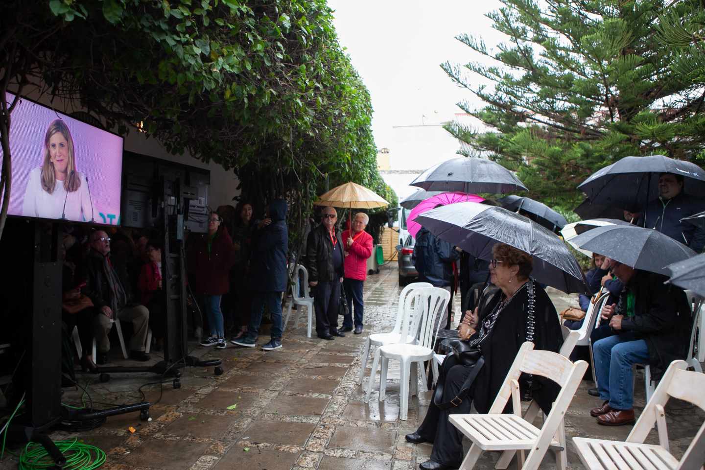 Un grupo de personas viendo el mitin del PSOE en Andalucía.