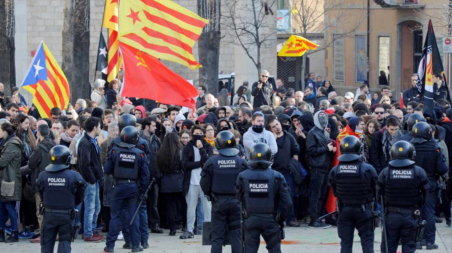 Mossos d'esquadra frente a las numerosas personas, muchas de ellas encapuchadas, que trataban de boicotear los actos conmemorativos de la Constitución en Girona.