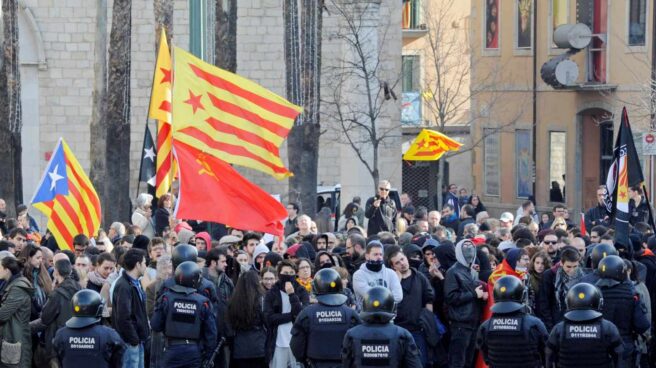 Mossos d'esquadra frente a las numerosas personas, muchas de ellas encapuchadas, que trataban de boicotear los actos conmemorativos de la Constitución en Girona.