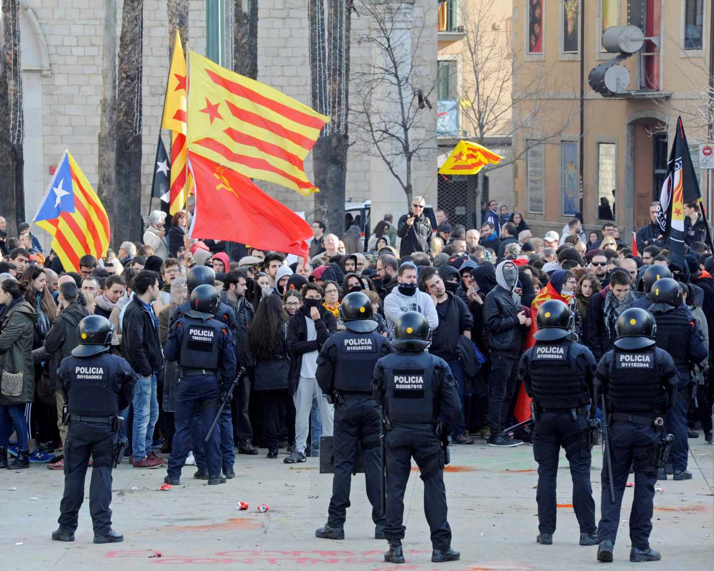 Mossos d'esquadra frente a las numerosas personas, muchas de ellas encapuchadas, que trataban de boicotear los actos conmemorativos de la Constitución en Girona.