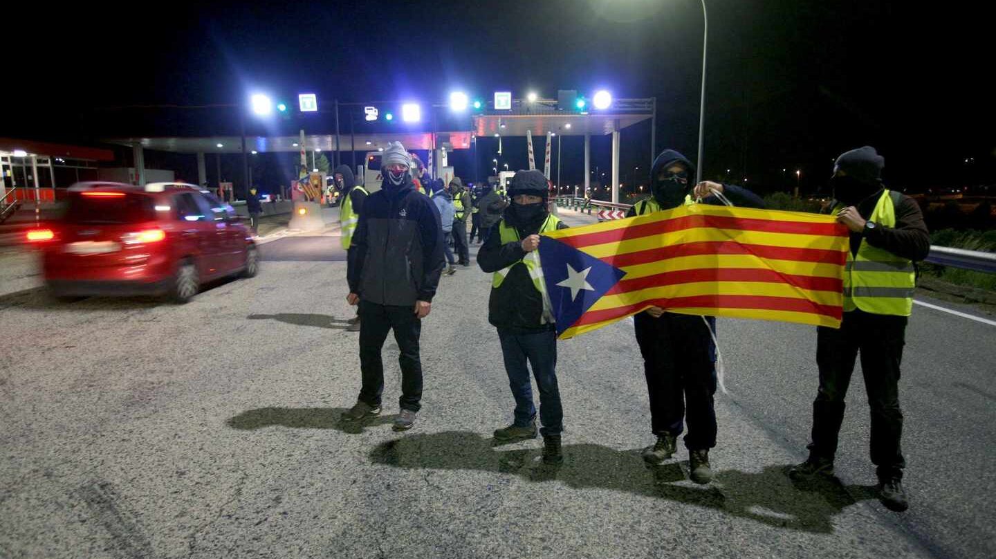 Un grupo de los Comités de Defensa de la República (CDR) levantan las barreras en la salida de la AP-7 en el peaje de L'Hospitalet de L'Infant, coincidiendo con las horas centrales de la operación retorno por el puente de la Constitución.