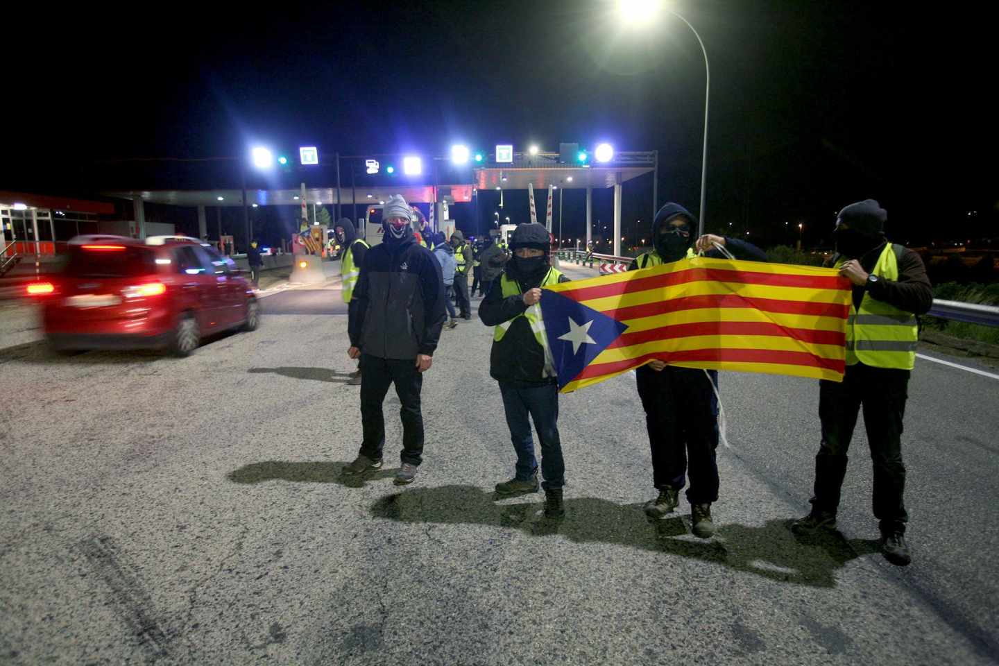 Un grupo de los Comités de Defensa de la República (CDR) levantan las barreras en la salida de la AP-7 en el peaje de L'Hospitalet de L'Infant, coincidiendo con las horas centrales de la operación retorno por el puente de la Constitución.