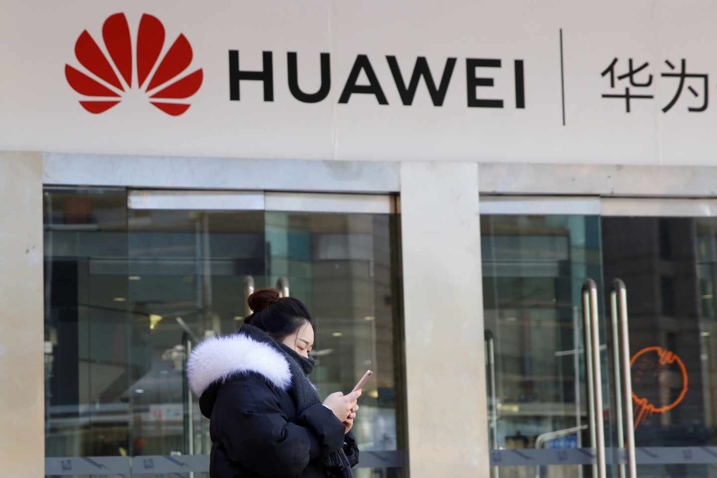 Una china pasa junto a una tienda de móviles Huawei en Pekín.