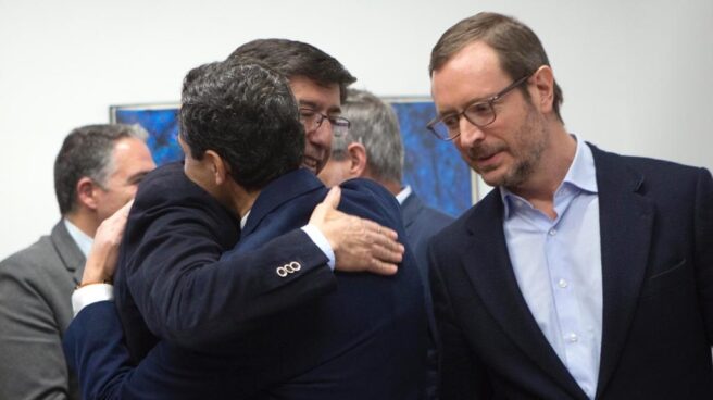 Juan Marín y Juanma Moreno se abrazan ante Javier Maroto en el parlamento andaluz.