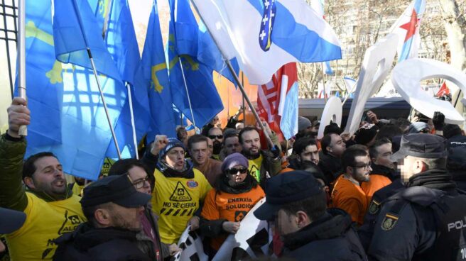 Miembros de la Policía Nacional ante trabajadores de Alcoa de Avilés y A Coruña durante la manifestación que ha tenido lugar hoy ante el Ministerio de Industria