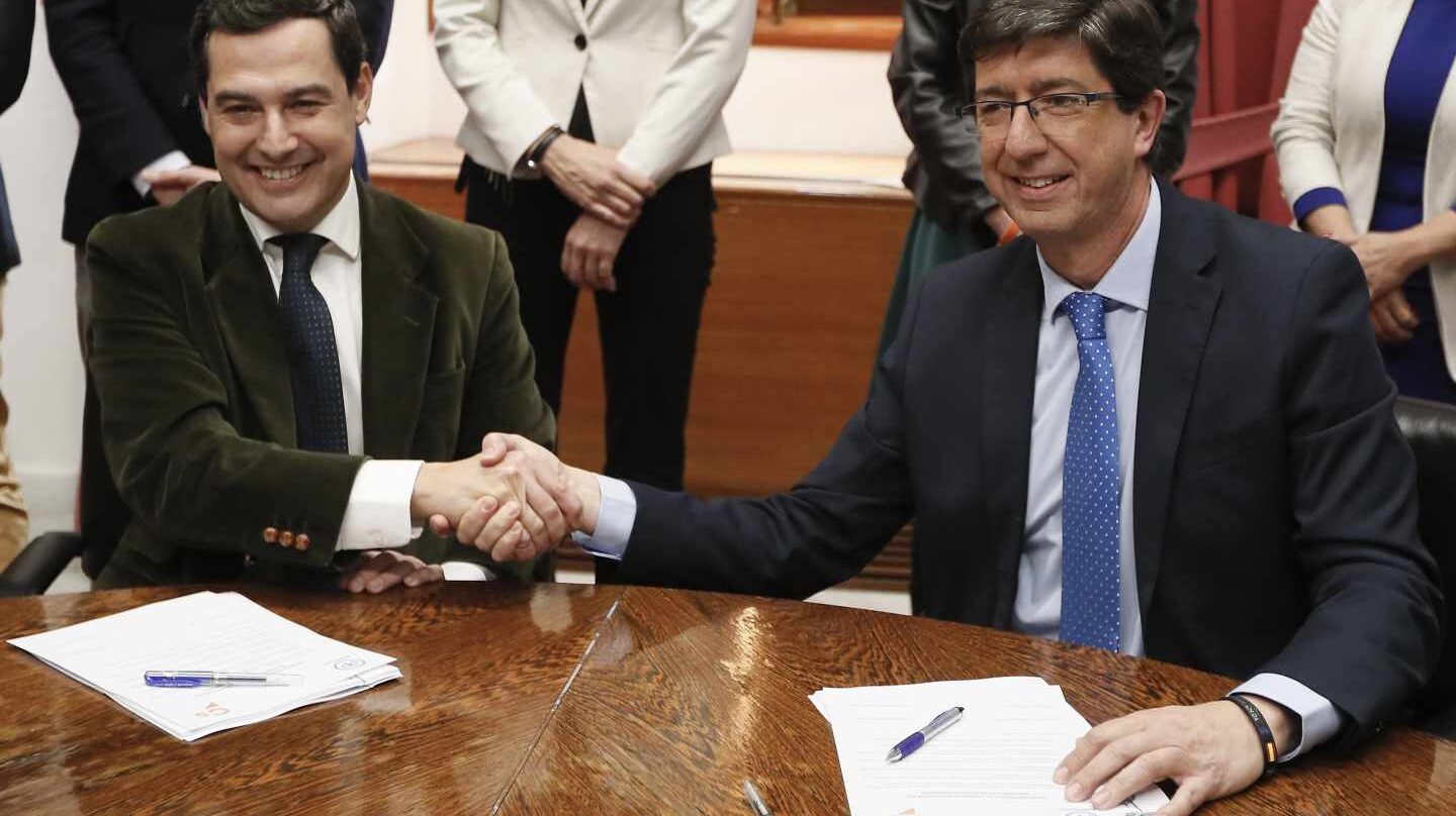 Juan Manuel Moreno Bonilla y Juan Marín se estrechan la mano en el Parlamento andaluz.