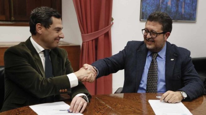 Juan Manuel Moreno estrecha la mano con el líder andaluz de Vox, Francisco Serrano.