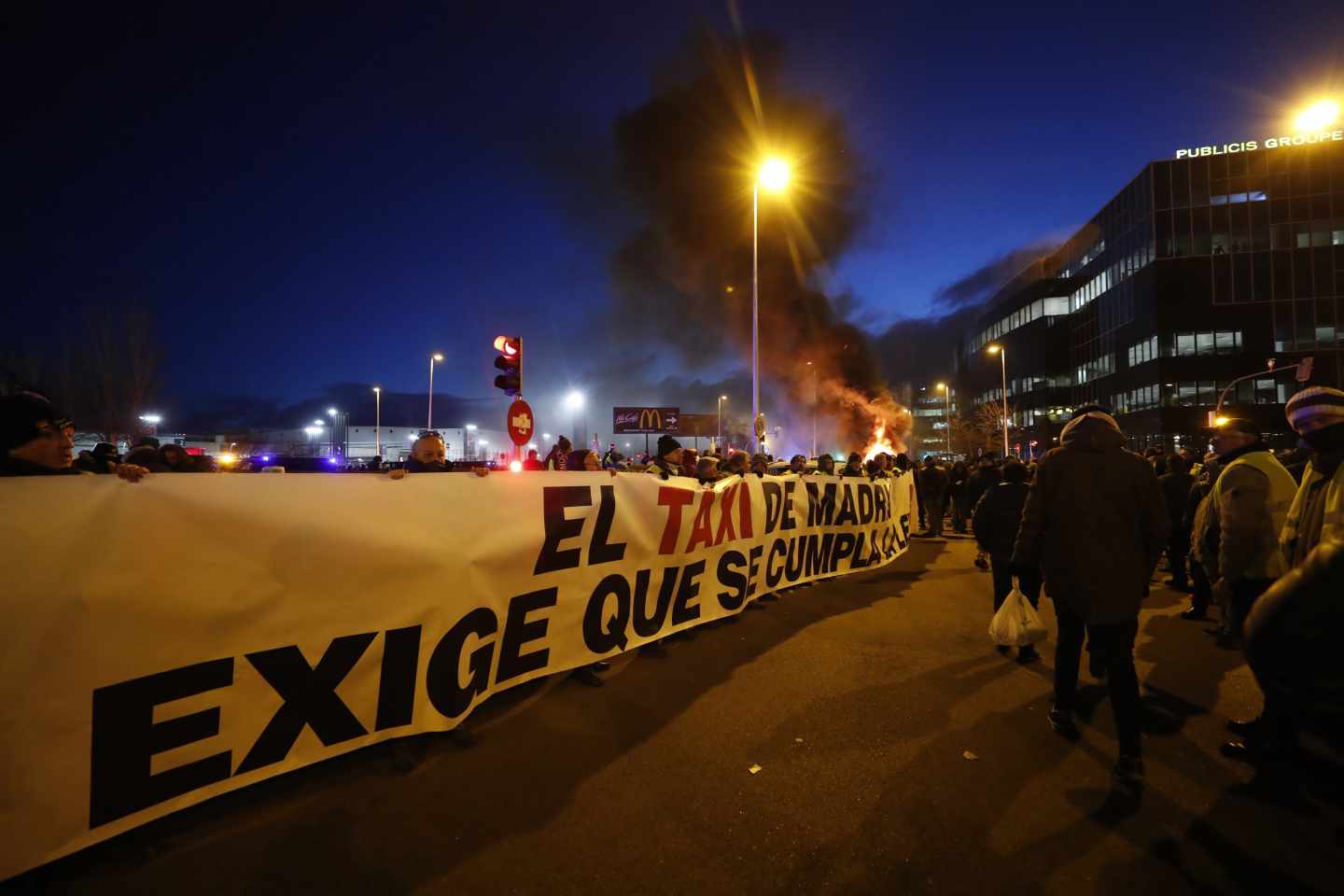 Los taxistas queman contenedores a la entrada de Ifema para impedir el paso a Fitur