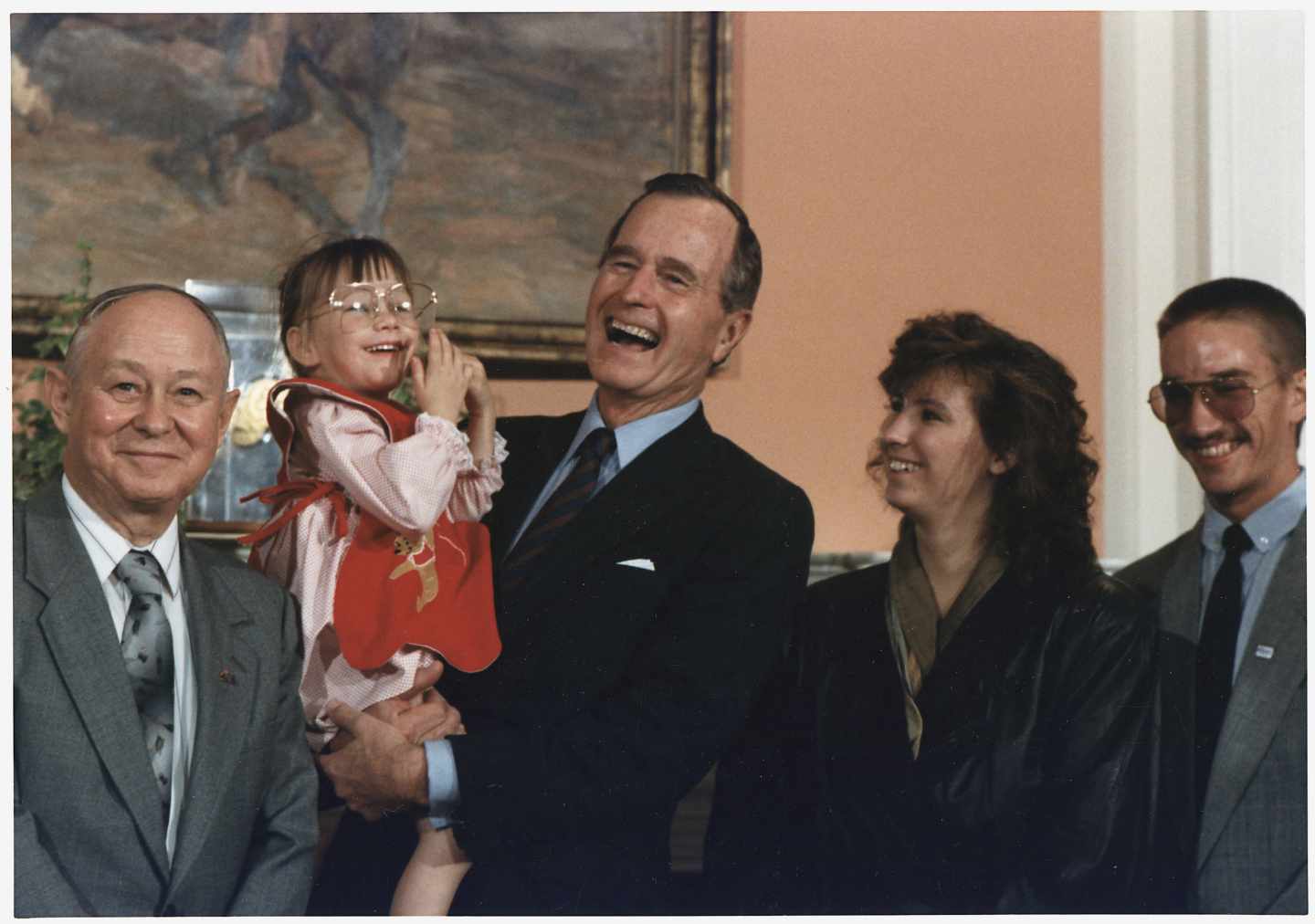 El ex presidente de Estados Unidos, George H.W. Bush sostiene en brazos a Jessica McClute, la niña rescatada de un pozo tras 58 horas atrapada