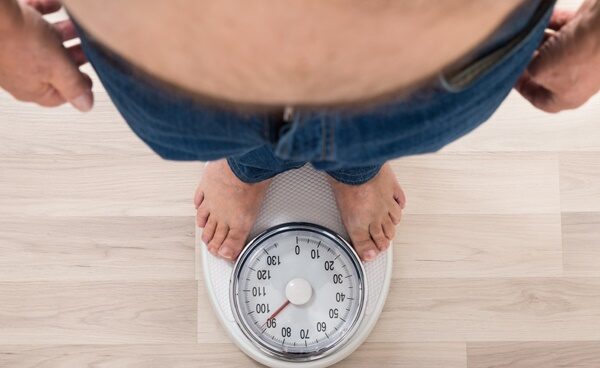 Low Section Of A Person Standing On Weighing Scale