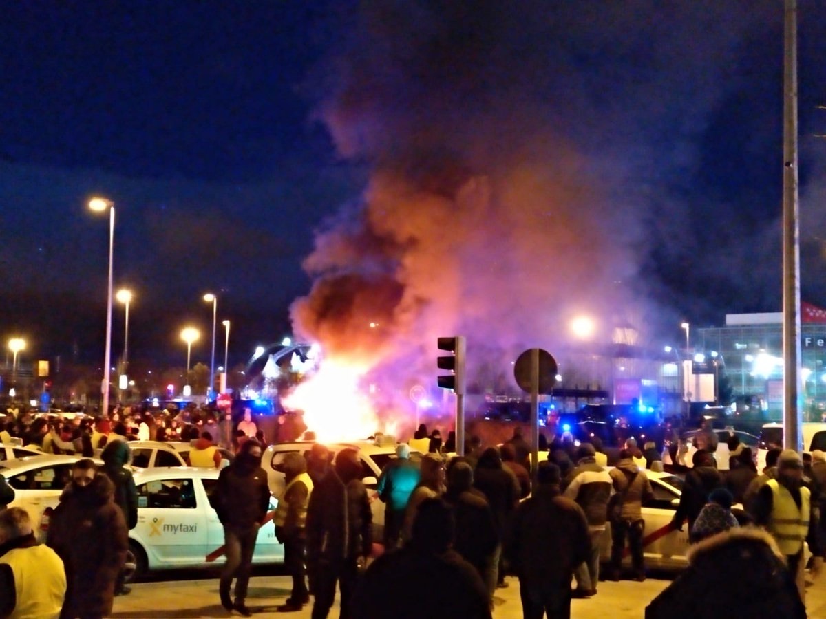 Taxistas queman contenedores a la entrada de Fitur (Ifema) en Madrid.