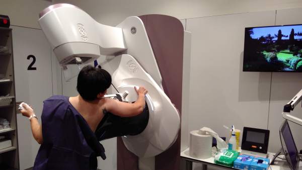 Una mujer realizando una mamografía.