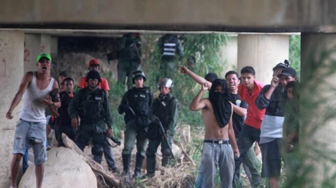 Vista de seguidores del gobierno del presidente de Venezuela, Nicolás Maduro, y miembros de la Policía venezolana durante los enfrentamientos con los manifestantes opositores, en el lado venezolano del Puente Internacional Simón Bolívar, este sábado.
