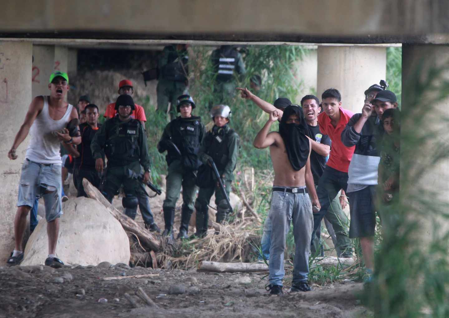 Vista de seguidores del gobierno del presidente de Venezuela, Nicolás Maduro, y miembros de la Policía venezolana durante los enfrentamientos con los manifestantes opositores, en el lado venezolano del Puente Internacional Simón Bolívar, este sábado.