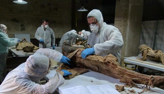 Especialistas manipulando una momia.