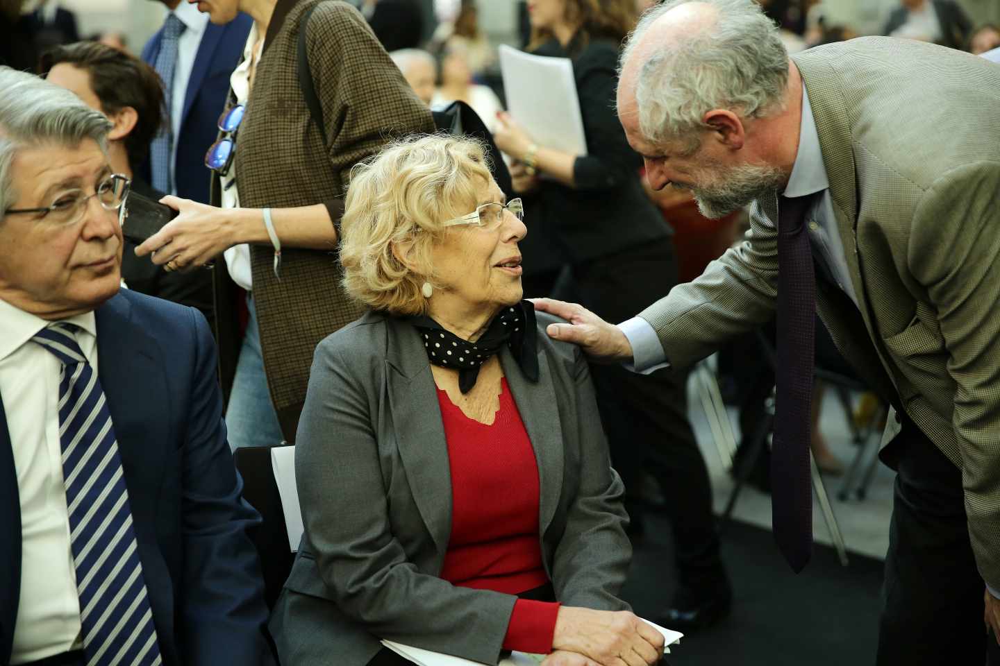 Luis Cueto saluda a Manuela Carmena en presencia de Enrique Cerezo.