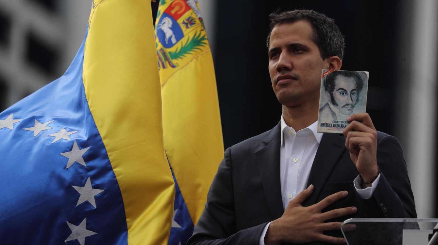 El presidente encargado de Venezuela, Juan Guaidó, muestra un retrato de Simón Bolívar.