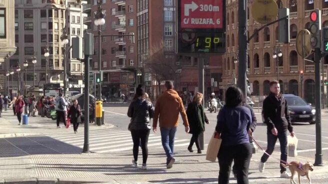 Imagen de archivo de personas abrigadas paseando por una calle de Valencia