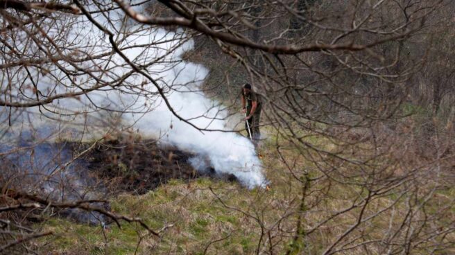 Un funcionario del Principado apaga restos de un incendio en el concejo de Belmonte.