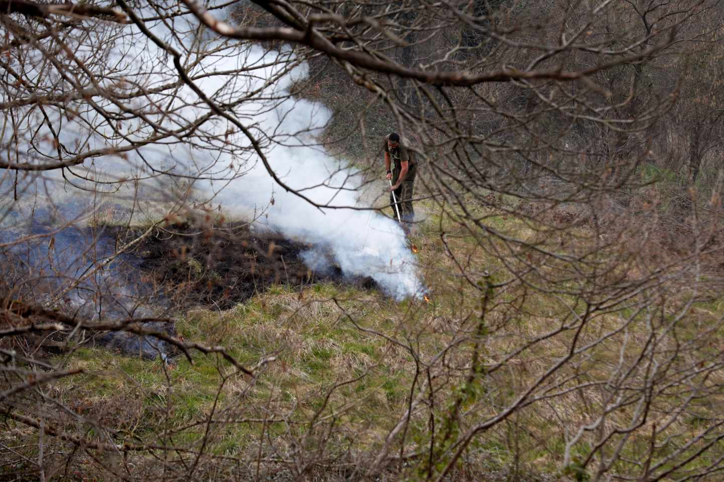 Un funcionario del Principado apaga restos de un incendio en el concejo de Belmonte.