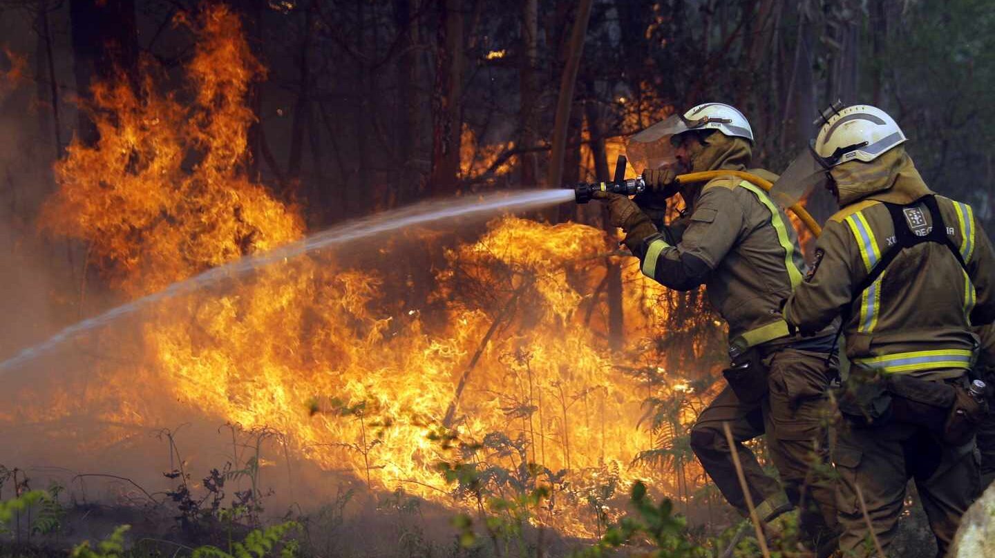 Los bomberos apagan uno de los numerosos focos del incendio en la localidad coruñesa de Rianxo