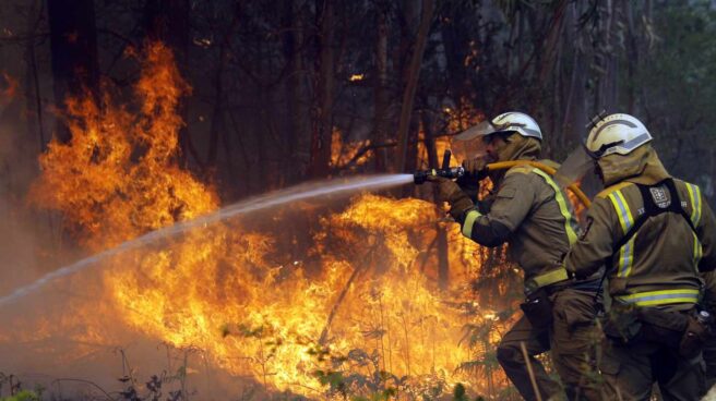 Los bomberos apagan uno de los numerosos focos del incendio en la localidad coruñesa de Rianxo