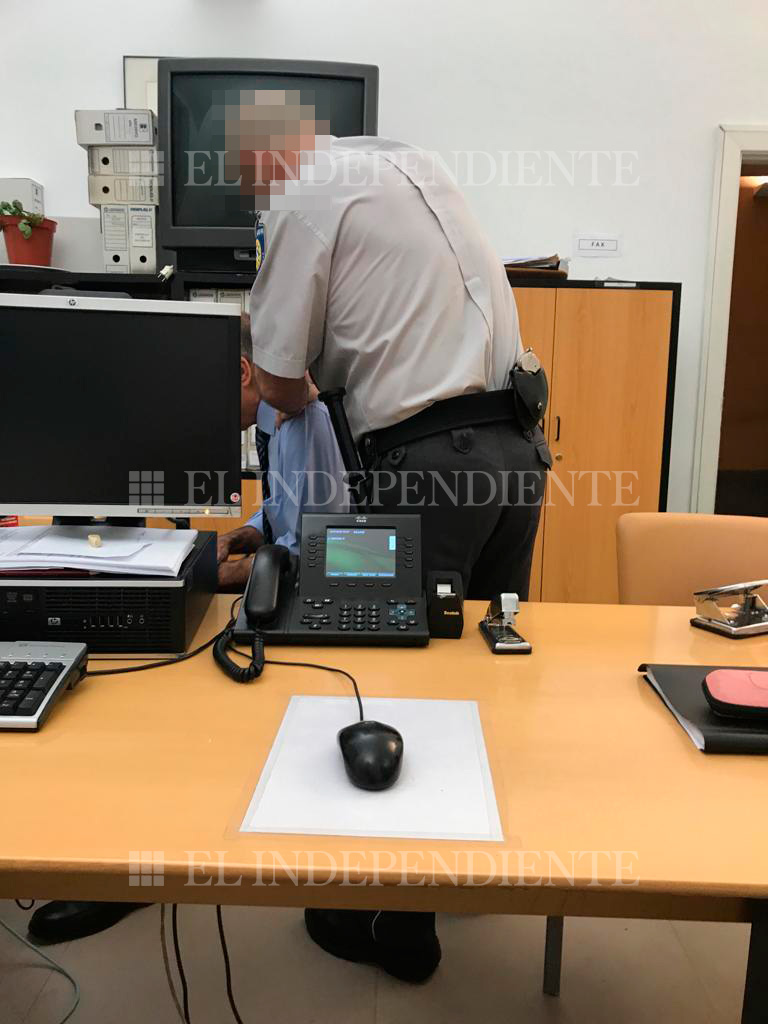 Un vigilante de seguridad de la Comunidad de Madrid da un masaje a uno de los funcionarios investigados por la Policía.