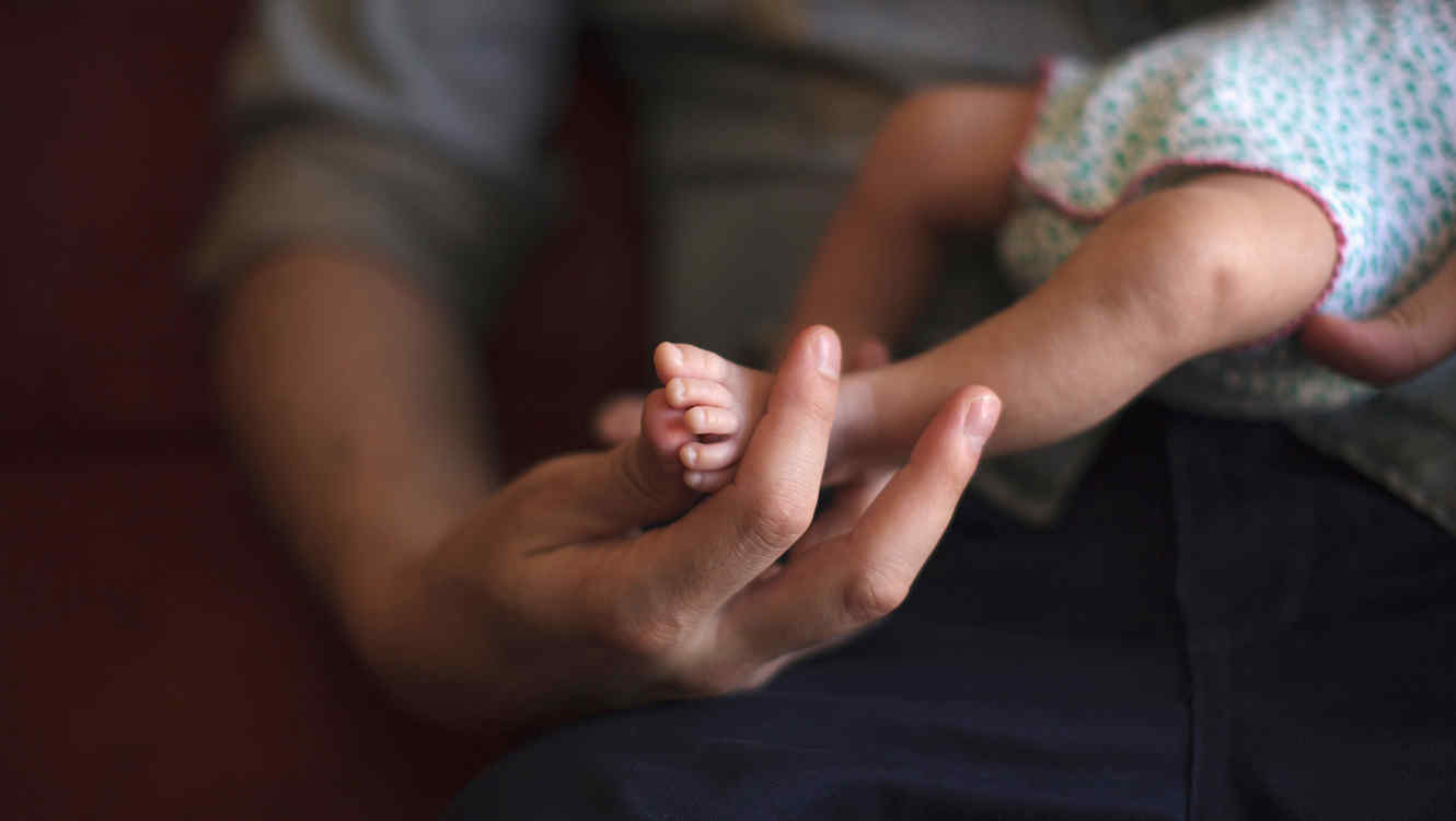 Un bebé en brazos de su padre.